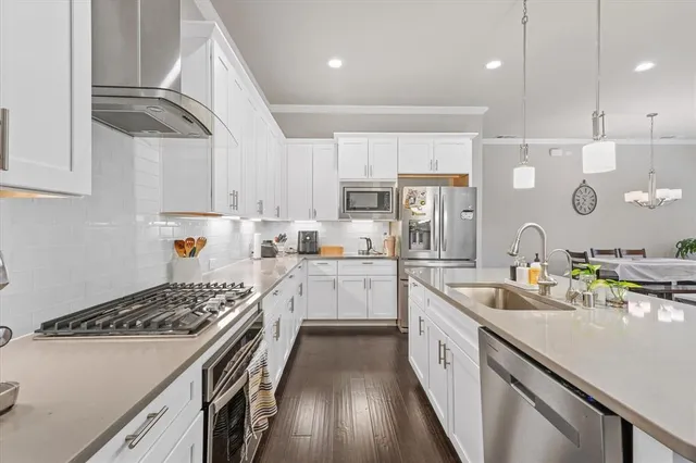 a kitchen with kitchen island white cabinets a sink stove and refrigerator