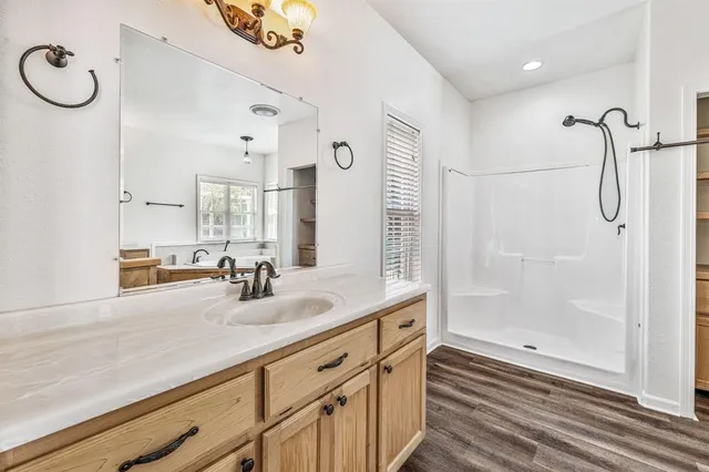 a bathroom with a double vanity sink mirror and shower