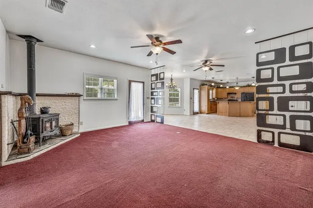 a furnished livingroom with windows and cabinet