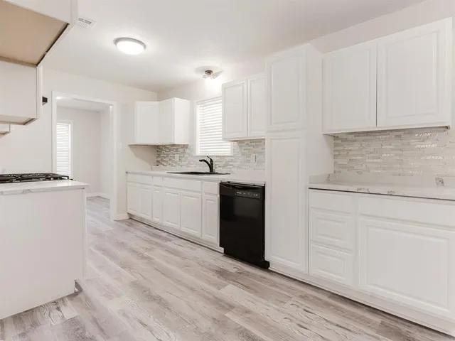 a kitchen with granite countertop white cabinets and white appliances