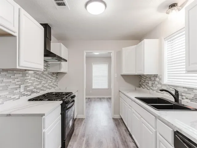 a kitchen that has a sink and a stove