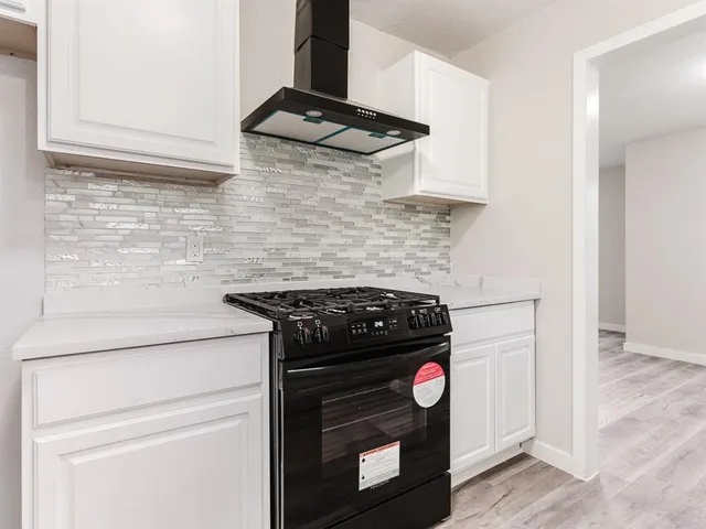 a stove top oven sitting inside of a kitchen
