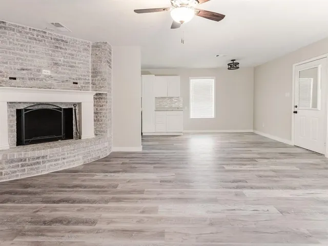 a view of empty room with wooden floor and fireplace