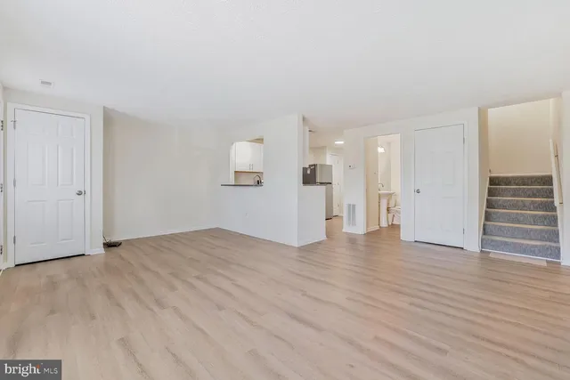 a view of empty room with wooden floor