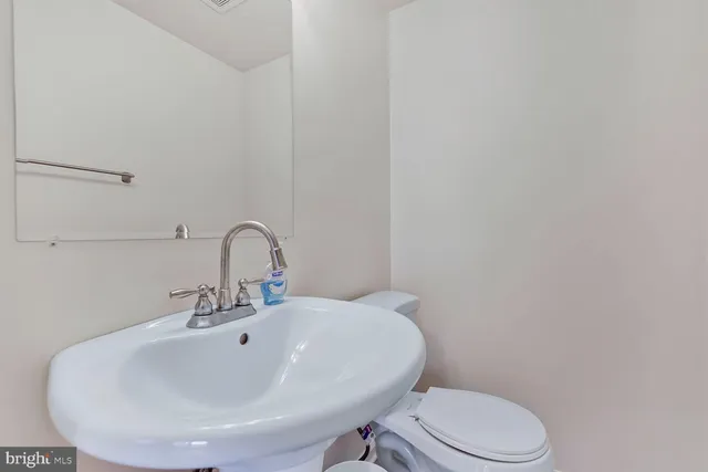 a bathroom with a sink a toilet and mirror