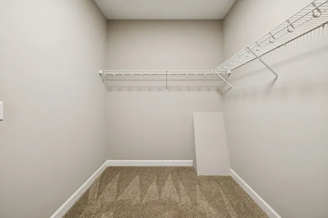 an empty room with windows and ceiling fan