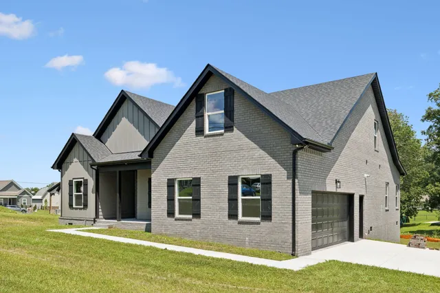 a view of a hallway with wooden floor and a bathroom