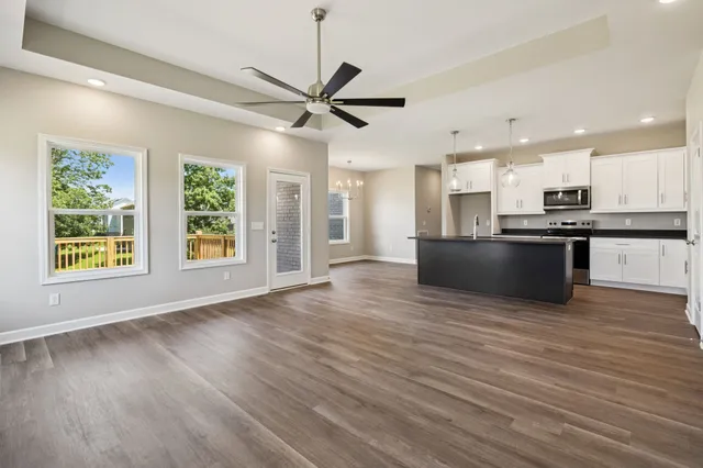 a view of a kitchen with a wooden floor and a ceiling fan