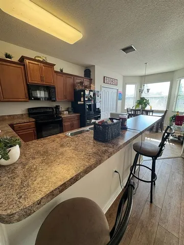 a kitchen with a table chairs microwave and cabinets