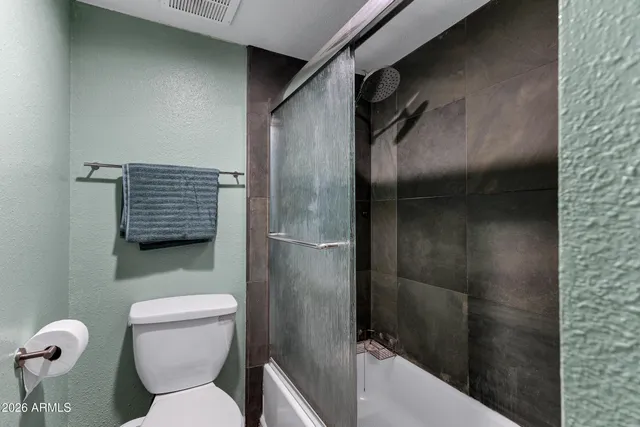 a bathroom with a toilet and a shower