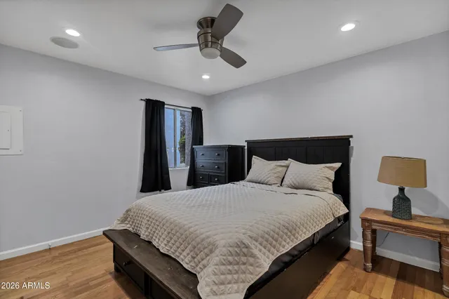 a bedroom with a bed and wooden floor