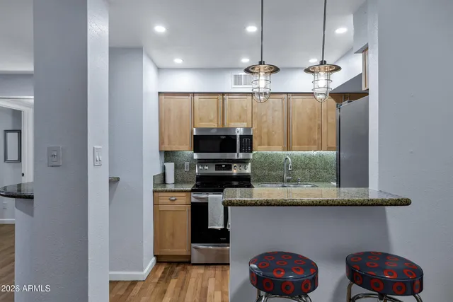 a kitchen with stainless steel appliances granite countertop a stove a sink and a microwave
