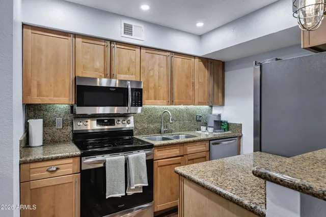 a kitchen with granite countertop a stove and a sink