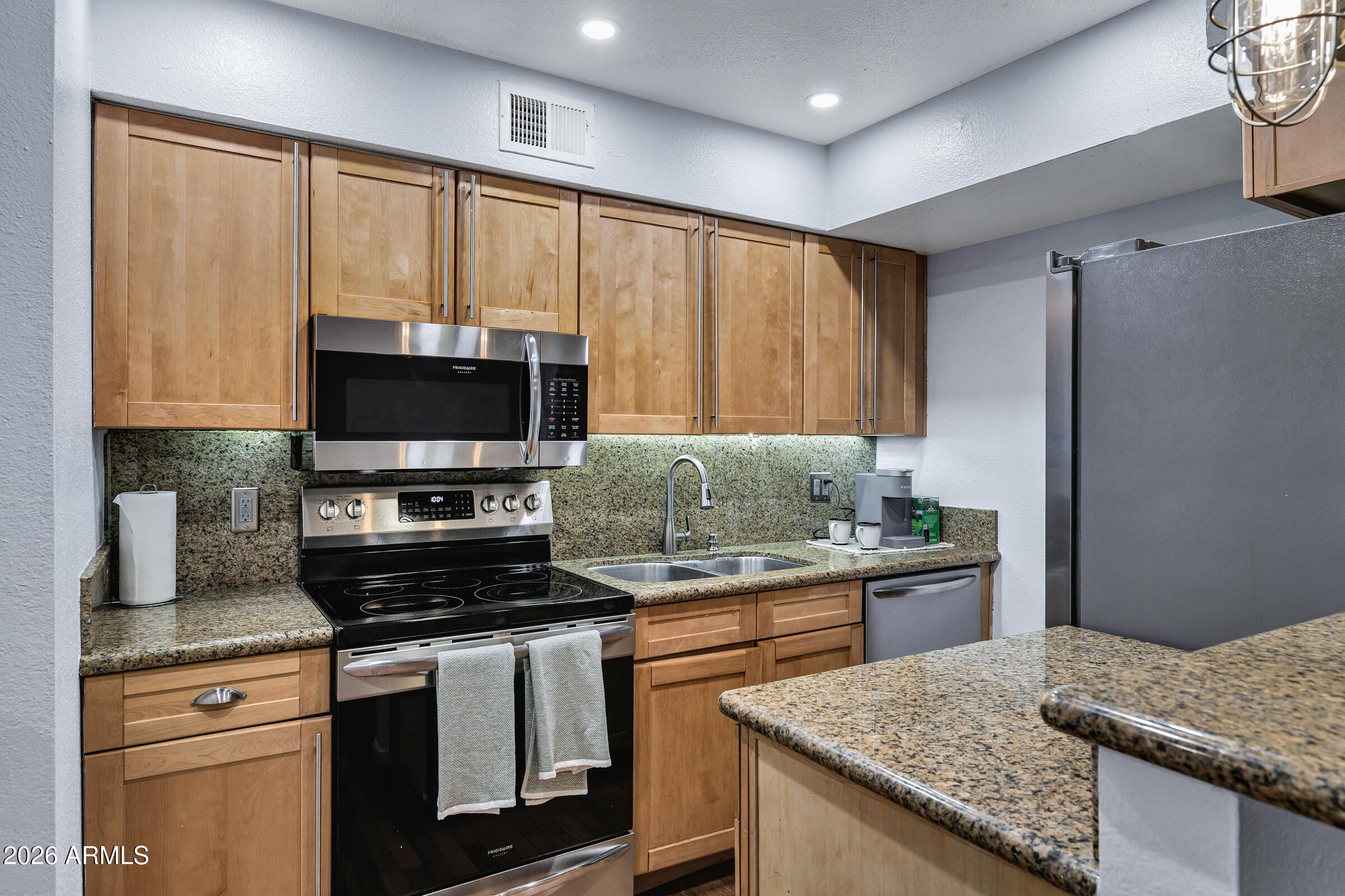 4410 North Longview Avenue, Unit 119 Phoenix, AZ 85014 - Photo 9 of 22 a kitchen with granite countertop a stove and a sink