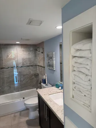 a bathroom with a granite countertop sink toilet and shower