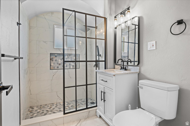 327 35th Street Ogden, UT 84401 - Photo 18 of 31 Modern bathroom featuring a walk-in shower with black-framed glass enclosure, white marble-look wall tiling, and a mosaic tiled shower floor