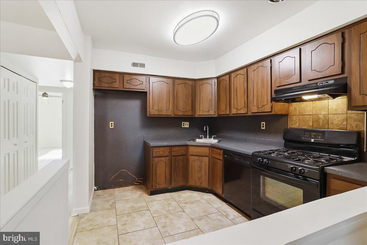 12062 Abby Road Philadelphia, PA 19154 - Photo 18 of 28 a kitchen with stainless steel appliances granite countertop a stove top oven a sink dishwasher and cabinets with wooden floor