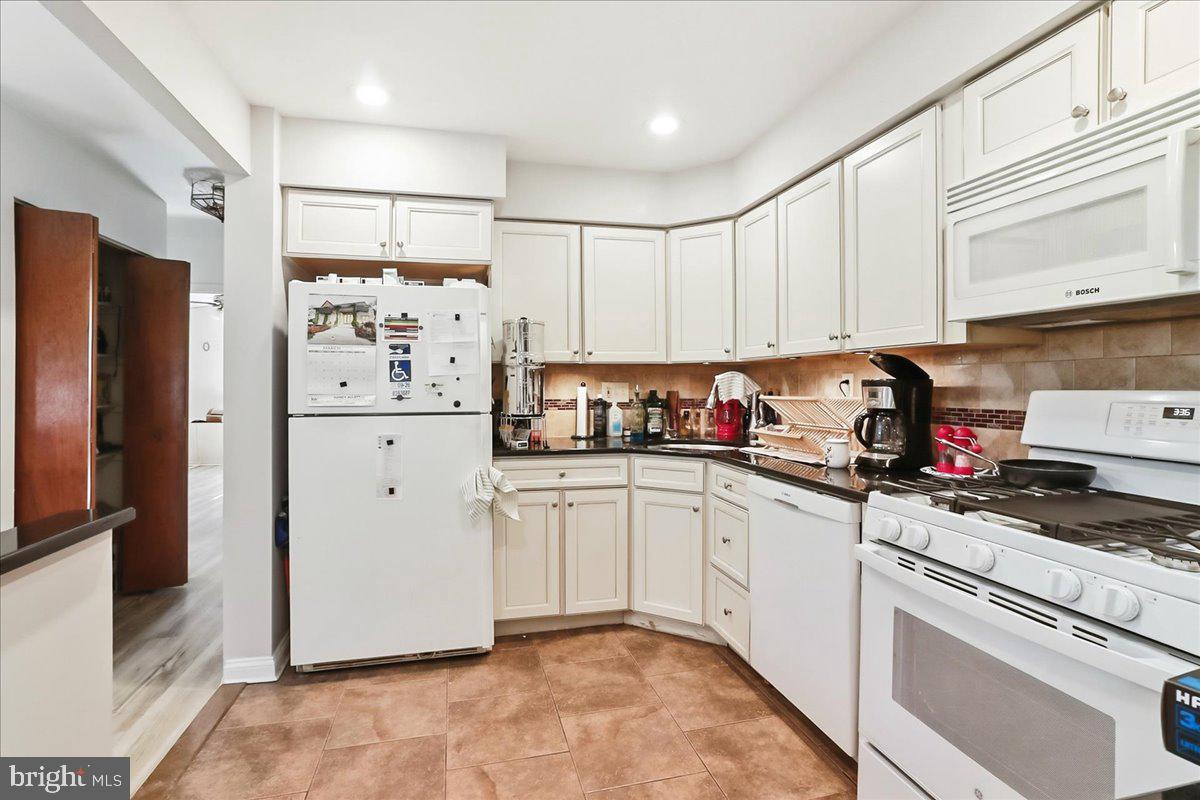 12062 Abby Road Philadelphia, PA 19154 - Photo 10 of 28 a kitchen with granite countertop a refrigerator a sink and white cabinets