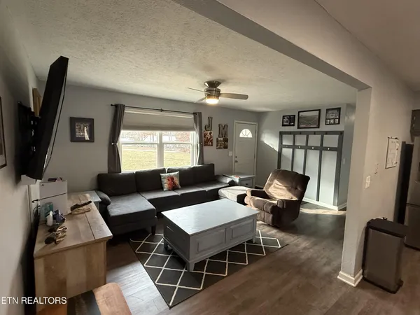 a living room with furniture a flat screen tv and a window