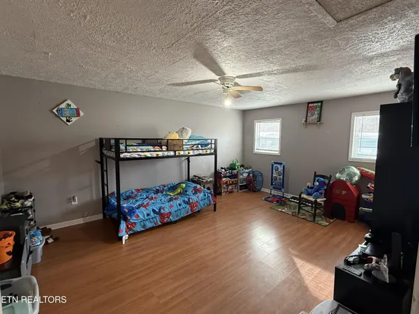 a bedroom with a bed and wooden floor