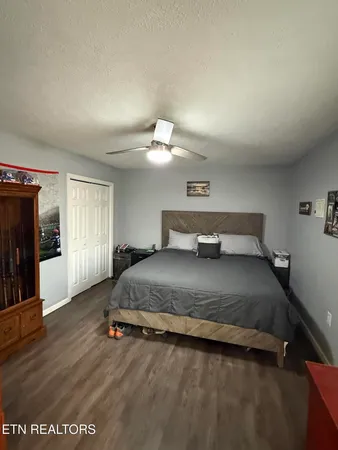 a bedroom with a beds chandelier and a window