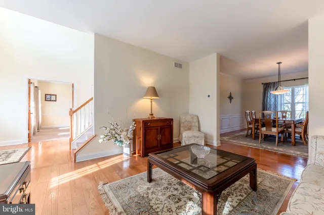 a open kitchen with stainless steel appliances granite countertop a stove a sink dishwasher a microwave oven and a dining table with wooden floor