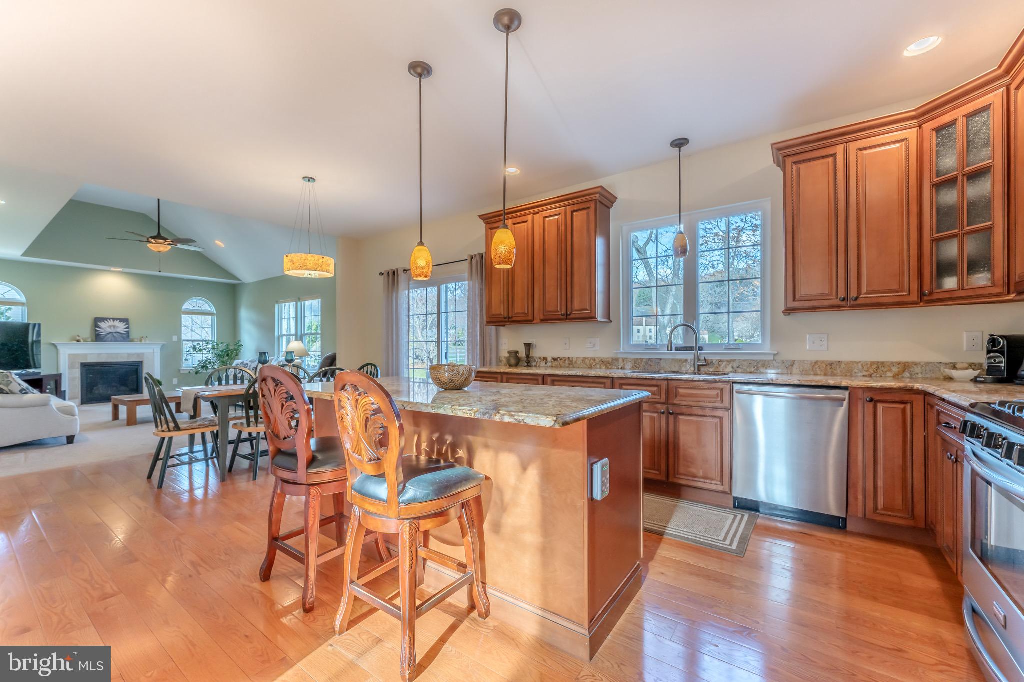 3505 Woodbyne Road Hellertown, PA 18055 - Photo 14 of 78 a open kitchen with stainless steel appliances granite countertop a stove a sink dishwasher a microwave oven and a dining table with wooden floor