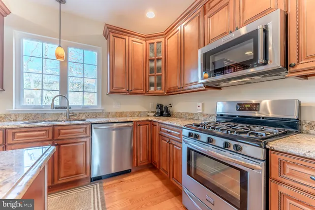a kitchen with stainless steel appliances granite countertop a stove a sink and a refrigerator