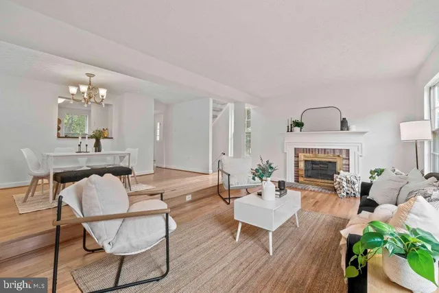 a living room with furniture a chandelier and a fireplace