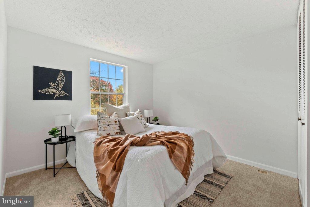 25 Capps Court Gaithersburg, MD 20878 - Photo 22 of 39 a bed sitting in a bedroom next to a window with a flat screen tv