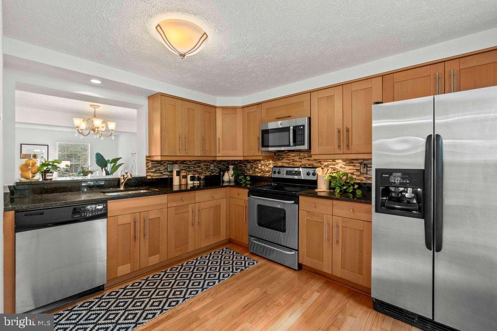 25 Capps Court Gaithersburg, MD 20878 - Photo 4 of 39 a kitchen with stainless steel appliances a stove a sink a microwave a refrigerator and cabinets