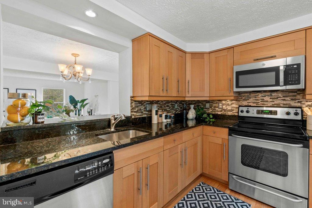 25 Capps Court Gaithersburg, MD 20878 - Photo 5 of 39 a kitchen with granite countertop a stove sink and microwave