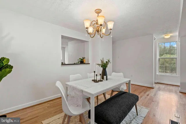 a view of a dining room with furniture wooden floor and a chandelier
