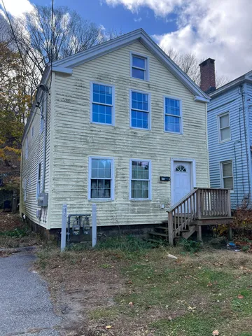 a view of a house with a yard and deck