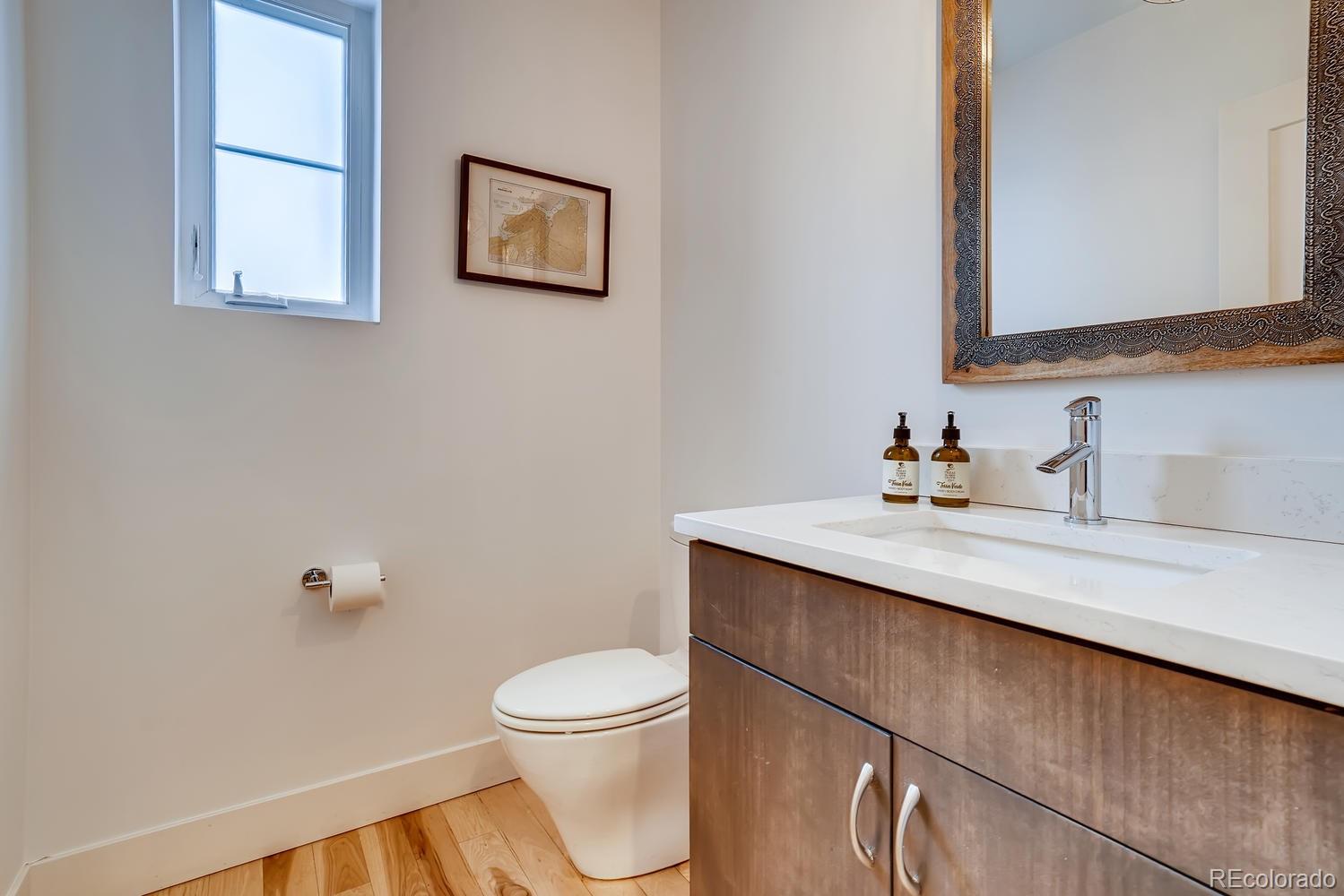 4565 Stuart Street Denver, CO 80212 - Photo 11 of 28 a bathroom with a toilet a sink and mirror
