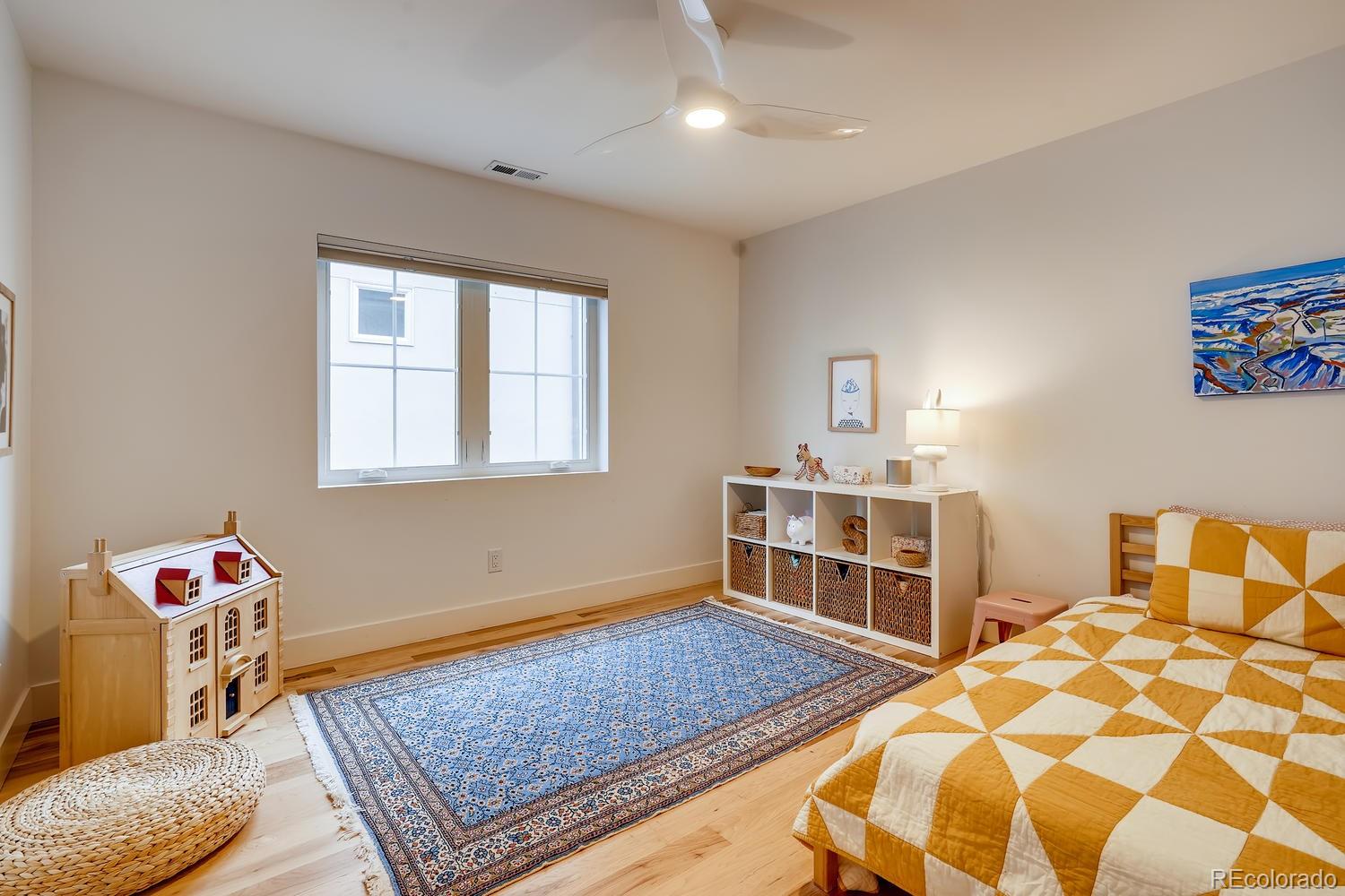 4565 Stuart Street Denver, CO 80212 - Photo 16 of 28 a bedroom with a bed and wooden floor