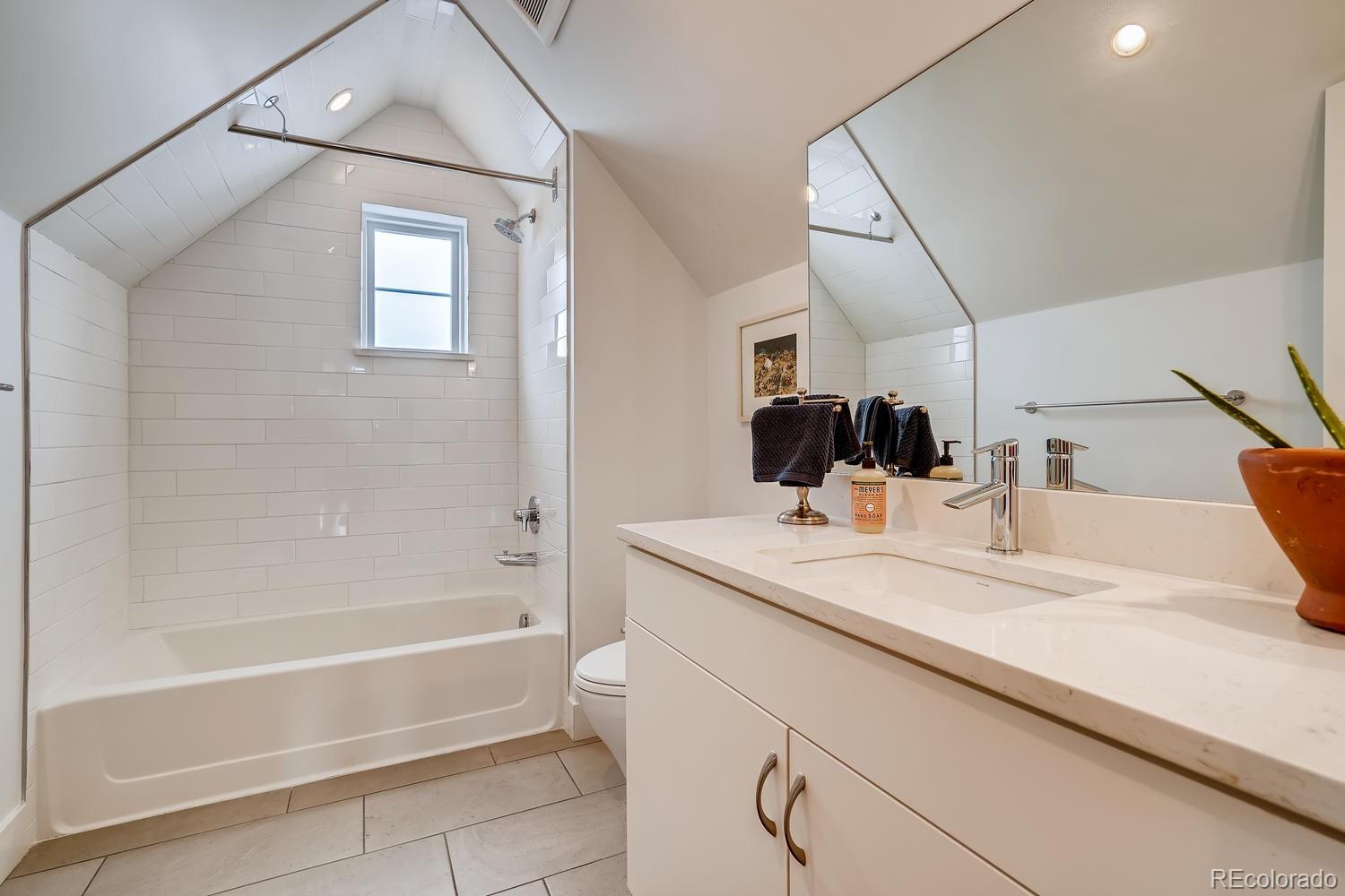 4565 Stuart Street Denver, CO 80212 - Photo 22 of 28 a bathroom with a tub sink and mirror