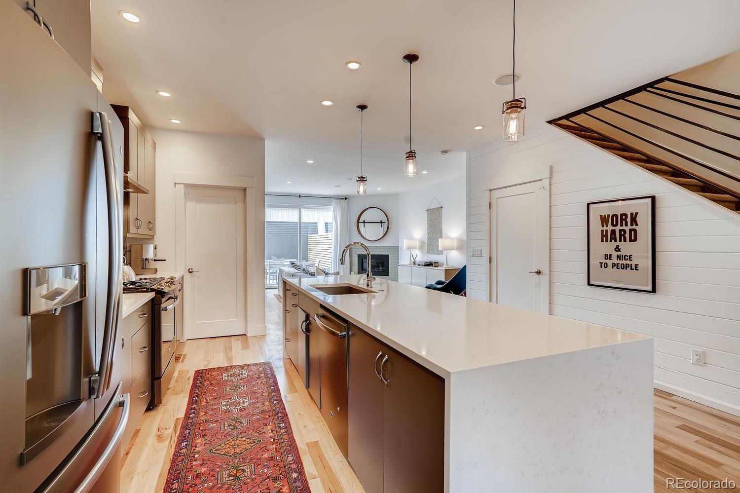 4565 Stuart Street Denver, CO 80212 - Photo 4 of 28 a large kitchen with stainless steel appliances a large counter top a stove and a refrigerator