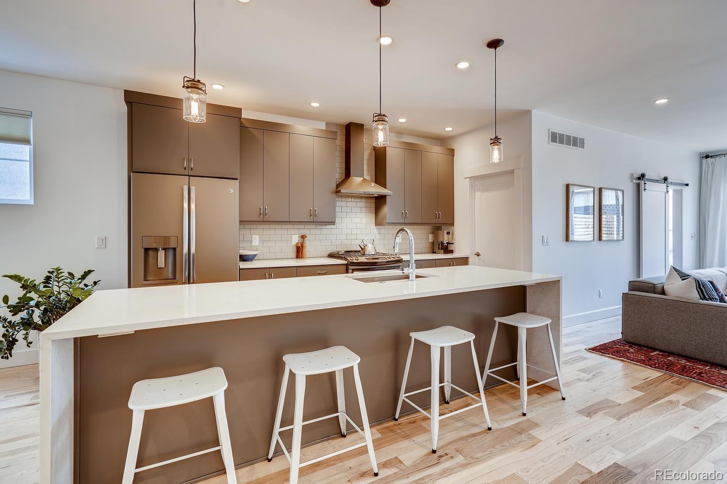 4565 Stuart Street Denver, CO 80212 - Photo 5 of 28 a kitchen with kitchen island a counter top space appliances and cabinets