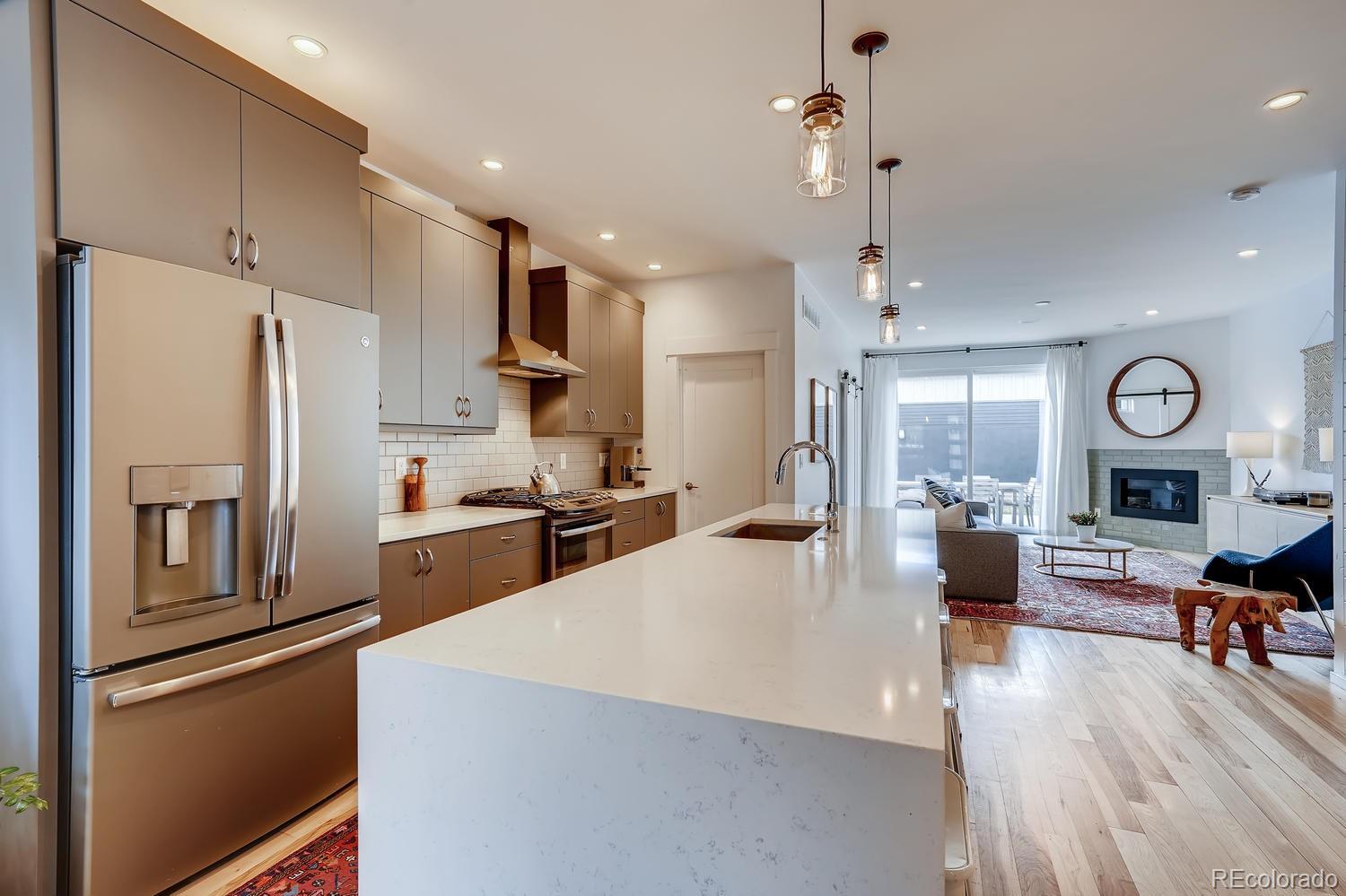 4565 Stuart Street Denver, CO 80212 - Photo 6 of 28 a large kitchen with sink cabinets and stainless steel appliances