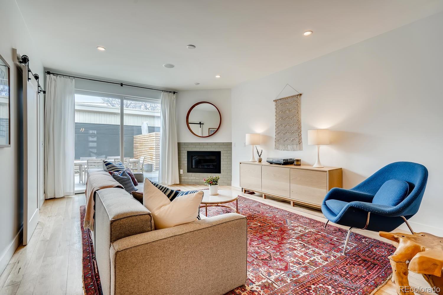 4565 Stuart Street Denver, CO 80212 - Photo 10 of 28 a living room with furniture a fireplace and a large window