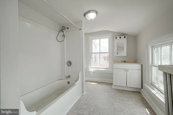 a bathroom with a tub sink and window