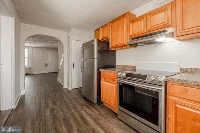 a kitchen with stainless steel appliances wooden floor sink and wooden cabinets