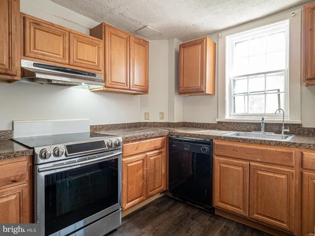 a kitchen with granite countertop white cabinets and stainless steel appliances