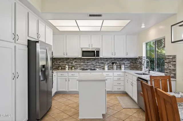 a kitchen with stainless steel appliances a refrigerator sink and cabinets
