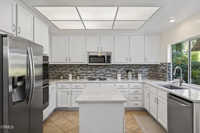 a kitchen with white cabinets sink and stainless steel appliances