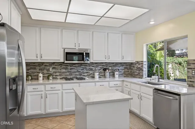 a kitchen with a refrigerator sink and cabinets