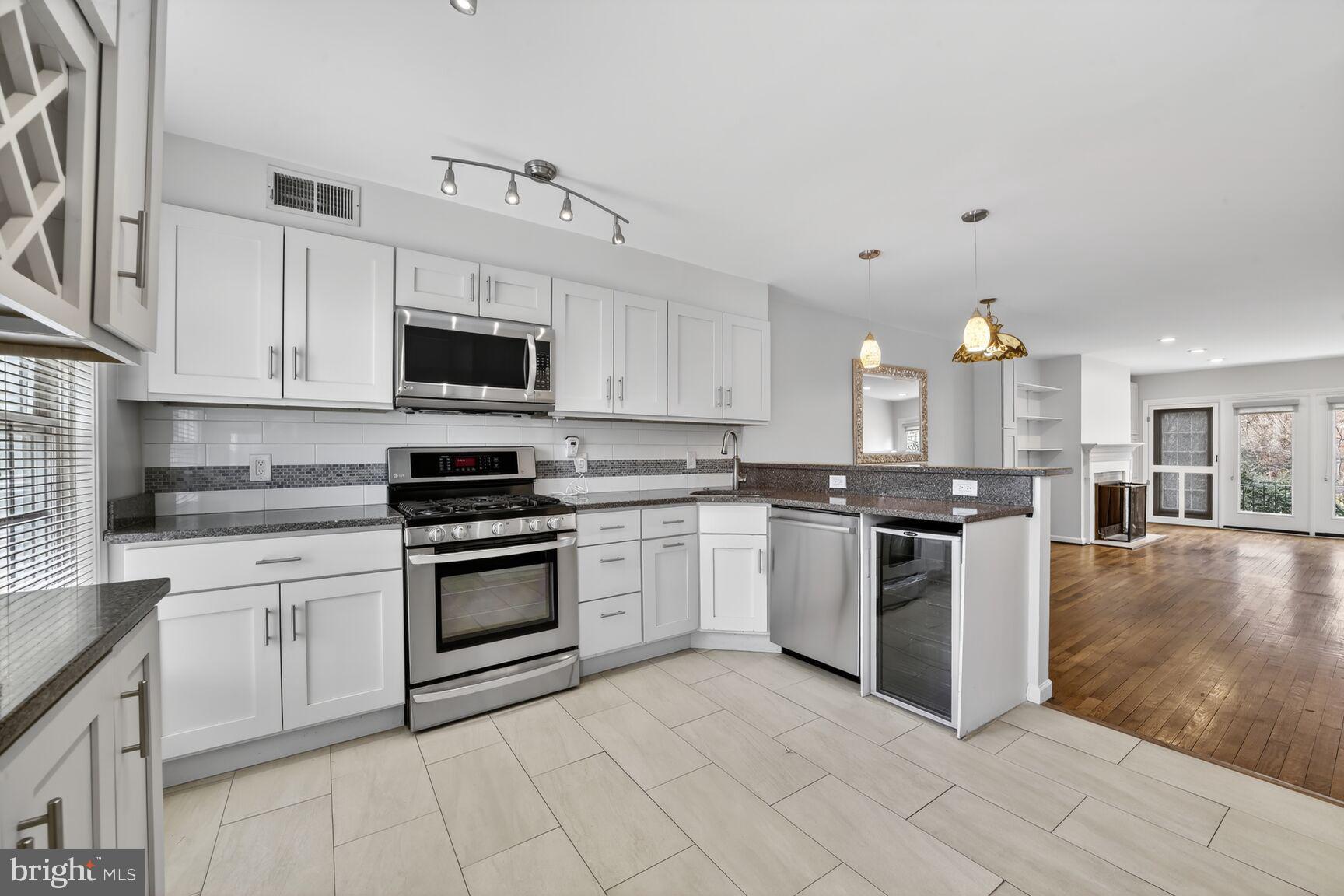 329 1/2 6th Street Southeast, Unit B Washington, DC 20003 - Photo 2 of 13 a kitchen with granite countertop a stove top oven and cabinets