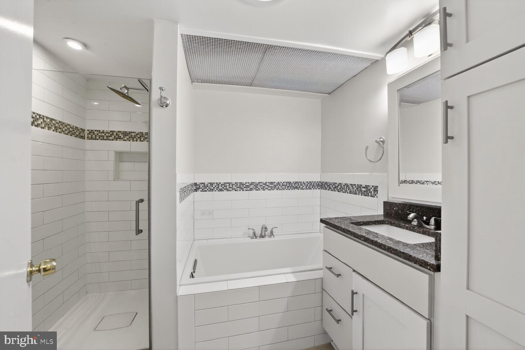 329 1/2 6th Street Southeast, Unit B Washington, DC 20003 - Photo 8 of 13 a bathroom with a granite countertop sink a mirror and shower