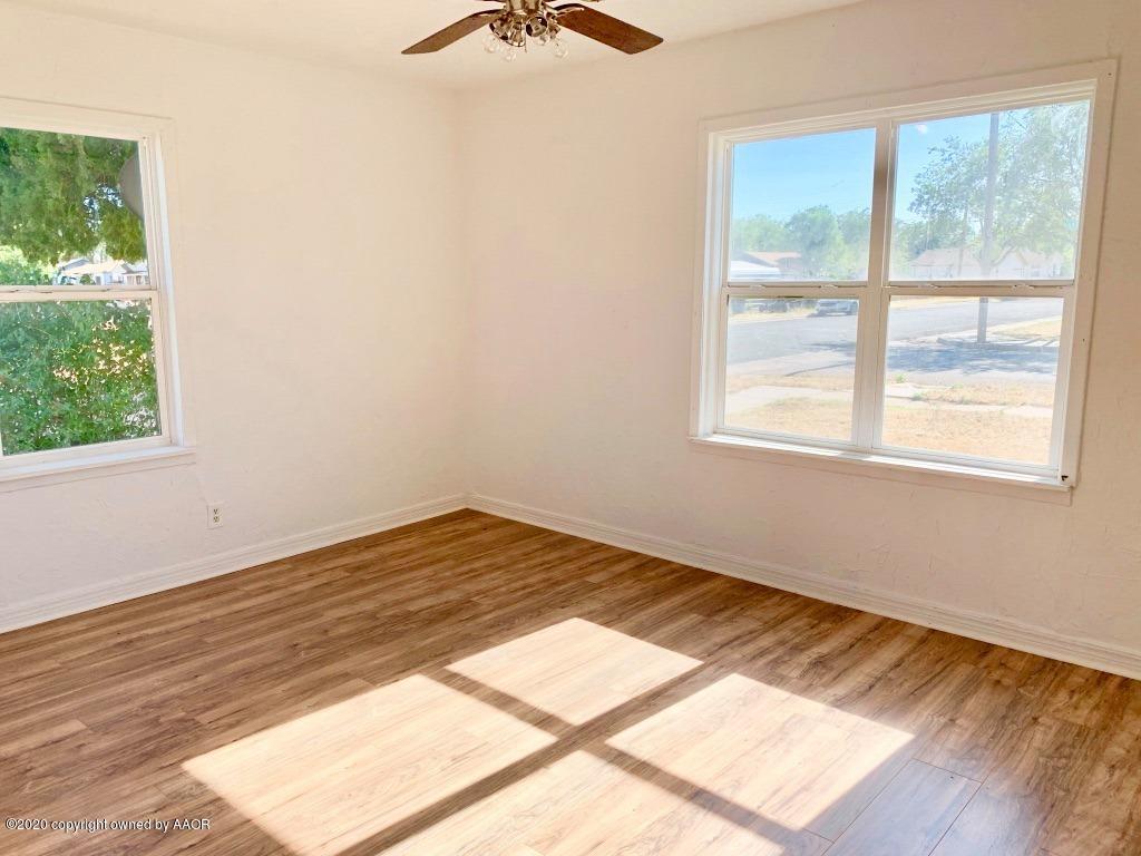 4131 South Harrison Street Amarillo, TX 79110 - Photo 4 of 8 an empty room with wooden floor and windows
